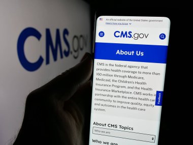 Stuttgart, Almanya - 01-28-2025: Medicare Medicaid Services 'in (CMS) web sayfası logolu cep telefonu tutan kişi. Telefon ekranının merkezine odaklan.