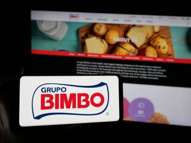 Stuttgart, Almanya - 01-28-2025: Meksikalı gıda şirketi Grupo Bimbo S.A.B. 'nin logosunu taşıyan kişi de C.V. web sitesinin önünde ekranda. Telefon ekranına odaklan.