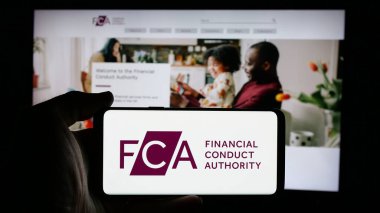 Stuttgart, Almanya - 01-29-2025: İnternet sayfası önünde ekranda İngiliz Denetleme Dairesi (FCA) logosu bulunan cep telefonu sahibi kişi. Telefon ekranına odaklan.
