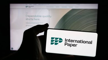 Stuttgart, Almanya - 01-29-2025: ABD 'li Uluslararası Kağıt Şirketi' nin logosunun bulunduğu cep telefonu sahibi kişi iş sayfasının önünde ekranda. Telefon ekranına odaklan.