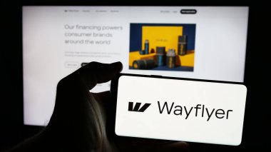 Stuttgart, Almanya - 01-29-2025: İrlandalı finans şirketi Wayflyer 'ın logosuyla cep telefonu sahibi kişi iş sayfasının önünde ekranda. Telefon ekranına odaklan.