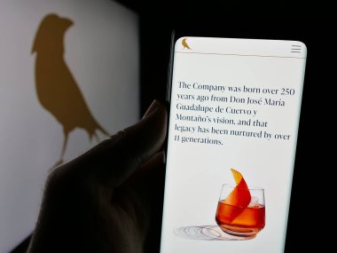 Stuttgart, Almanya - 01-30-2025: Meksika şirketi Becle SAB de CV 'nin (Cuervo) web sayfası logolu cep telefonu tutan kişi. Telefon ekranının merkezine odaklan.