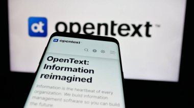 Stuttgart, Almanya - 01-30-2025: Kanadalı yazılım şirketi OpenText Corporation 'ın web sitesi ile cep telefonu iş logosu önünde ekranda. Telefon ekranının sol üst kısmına odaklan.