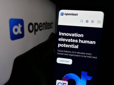 Stuttgart, Almanya - 01-30-2025: Kanadalı yazılım şirketi OpenText Corporation 'ın web sayfası ve logosu olan kişi. Telefon ekranının merkezine odaklan.