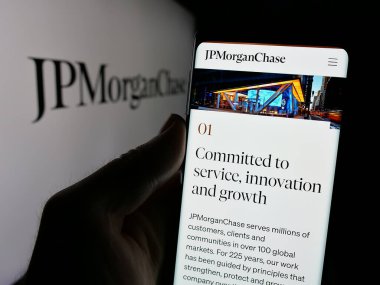 Stuttgart, Almanya - 01-30-2025: ABD 'li finans hizmetleri şirketi JPMorgan Chase Co' nun internet sayfası ile cep telefonu tutan kişi logolu ekranda. Telefon ekranının merkezine odaklan.