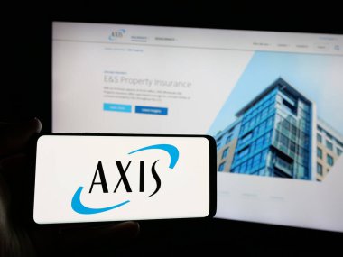 Stuttgart, Almanya - 01-30-2025: Finans şirketi AXIS Capital Holding Limited 'in logosuna sahip akıllı telefon sahibi kişi web sitesinin önünde ekranda görülüyor. Telefon ekranına odaklan.