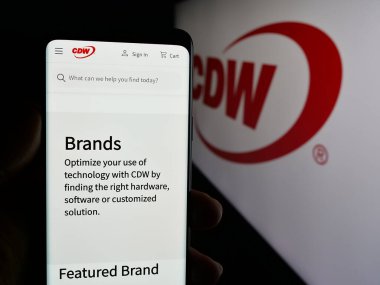 Stuttgart, Almanya - 01-30-2025: ABD 'li bilişim teknolojisi şirketi CDW Corporation' ın web sayfası ve logosu olan cep telefonu sahibi kişi. Telefon ekranının merkezine odaklan.