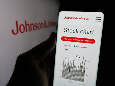 Stuttgart, Almanya - 01-30-2025: ABD 'li ilaç şirketi Johnson ve Johnson' ın internet sayfası logolu akıllı telefon sahibi kişi. Telefon ekranının merkezine odaklan.
