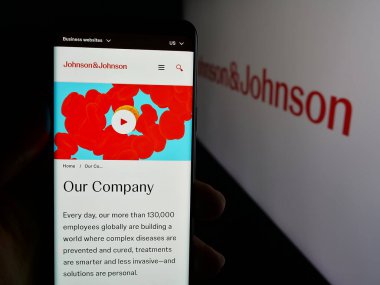 Stuttgart, Almanya - 01-30-2025: ABD 'li ilaç şirketi Johnson ve Johnson' ın internet sayfası logolu cep telefonu tutan kişi. Telefon ekranının merkezine odaklan.
