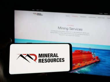 Stuttgart, Almanya - 01-30-2025: Web sitesi önünde üzerinde maden şirketi Mineral Resources Limited (Mineral Resources Limited) logosu bulunan akıllı telefon sahibi kişi. Telefon ekranına odaklan.