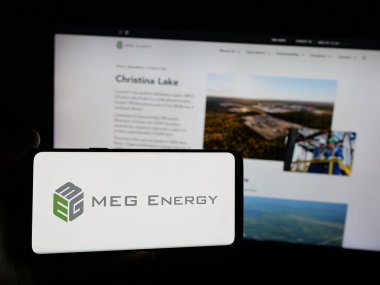 Stuttgart, Almanya - 01-30-2025: Kanadalı petrol şirketi MEG Energy Corp 'un logosunu elinde tutan kişi web sitesinin önünde ekranda. Telefon ekranına odaklan.