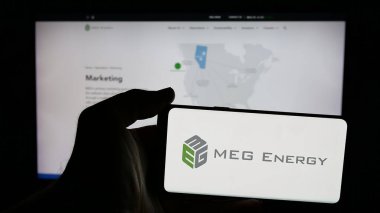 Stuttgart, Almanya - 01-30-2025: Kanadalı petrol şirketi MEG Energy Corp 'un logosunun bulunduğu cep telefonu sahibi kişi iş sayfasının önünde ekranda. Telefon ekranına odaklan.