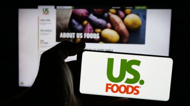 Stuttgart, Almanya - 01-31-2025: İnternet sayfasının önünde ekranda US Foods Holding Corp. 'un logosunun bulunduğu cep telefonu sahibi kişi. Telefon ekranına odaklan.