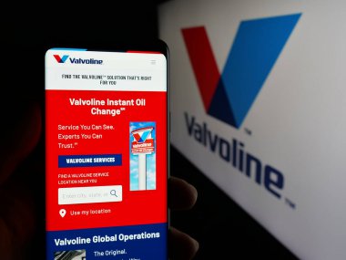 Stuttgart, Almanya - 01-31-2025: ABD 'li otomotiv hizmetleri şirketi Valvoline Inc.' in web sayfası ile cep telefonu elinde bulunan kişi logo ile ekranda. Telefon ekranının merkezine odaklan.