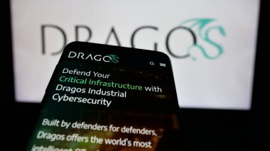 Stuttgart, Germany - 01-31-2025: Smartphone with website of US cybersecurity company Dragos Inc. on screen in front of business logo. Focus on top-left of phone display. clipart