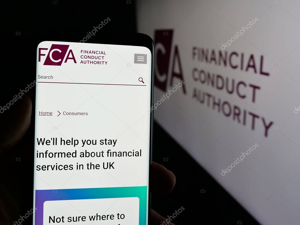 Stuttgart, Germany - 01-29-2025: Person holding mobile phone with website of British regulator Financial Conduct Authority (FCA) on screen with logo. Focus on center of phone display.