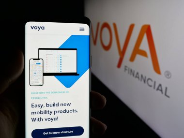 Stuttgart, Almanya - 01-31-2025: ABD 'li finans şirketi Voya Financial Inc.' in web sayfası ile akıllı telefon sahibi kişi logo önünde ekranda. Telefon ekranının merkezine odaklan.