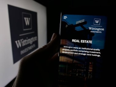 Stuttgart, Almanya - 01-31-2025: Holding şirketi Wittington Yatırımları Limited 'in web sayfası olan cep telefonu logolu kişi. Telefon ekranının merkezine odaklan.