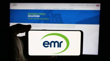 Stuttgart, Almanya - 03-04-2025: İngiliz Avrupa Metal Geri Dönüşüm Şirketi 'nin logosunun bulunduğu cep telefonu sahibi kişi iş sayfasının önünde ekranda görülüyor. Telefon ekranına odaklan.