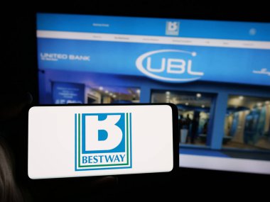 Stuttgart, Almanya - 03-04-2025: İngiliz Bestway Group Limited şirketinin logosuna sahip akıllı telefon sahibi kişi iş sitesinin önünde ekranda görülüyor. Telefon ekranına odaklan.