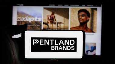 Stuttgart, Almanya - 03-04-2025: İngiliz perakende şirketi Pentland Group plc 'in logosuyla cep telefonu sahibi kişi iş sayfasının önünde ekranda. Telefon ekranına odaklan.