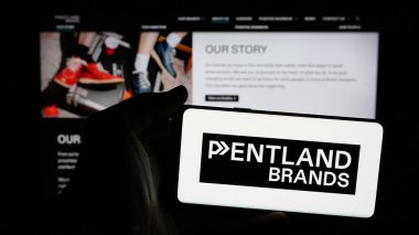 Stuttgart, Almanya - 03-04-2025: İngiliz perakende şirketi Pentland Group plc 'in logosunun bulunduğu cep telefonu sahibi kişi iş sayfasının önünde ekranda. Telefon ekranına odaklan.
