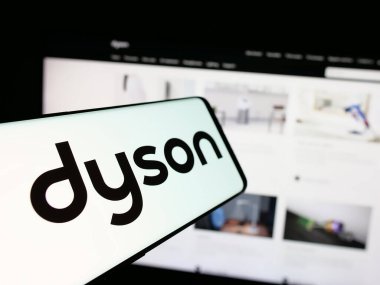 Stuttgart, Almanya - 03-04-2025: Ev aletleri şirketi Dyson Limited 'in logosuna sahip akıllı telefon iş sitesinin önünde ekranda. Telefon ekranının merkez soluna odaklan.