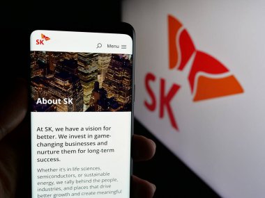 Stuttgart, Almanya - 03-13-2025: Güney Koreli şirket SK Group 'un logosu olan web sayfası logonun önünde ekranda. Telefon ekranının merkezine odaklan.