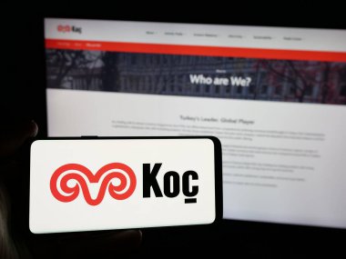 Stuttgart, Almanya - 03-13-2025: Türk sanayi şirketi Koç Holding A.S. 'nin logosunu taşıyan kişi iş dünyasının web sitesi önünde ekranda görülüyor. Telefon ekranına odaklan.