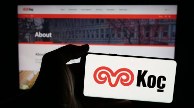 Stuttgart, Almanya - 03-13-2025: Türk sanayi şirketi Koç Holding A.S. 'nin logosunun bulunduğu cep telefonu sahibi kişi iş sayfasının önünde ekranda görülüyor. Telefon ekranına odaklan.
