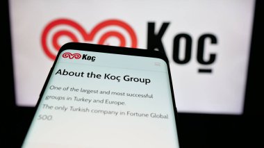 Stuttgart, Almanya - 03-13-2025: Türk sanayi şirketi Koç Holding A.S. 'nin logosunun yer aldığı cep telefonu, iş dünyasının web sitesi önünde ekranda. Telefon ekranının sol üst kısmına odaklan.