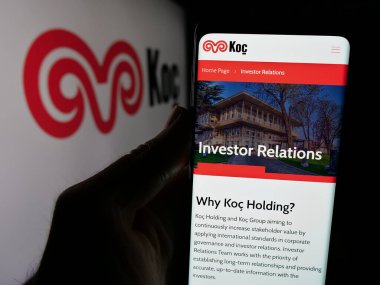 Stuttgart, Almanya - 03-13-2025: Türk sanayi kuruluşu Koç Holding A.S. 'nin internet sayfası ile cep telefonu tutan kişi logonun önünde ekranda görülüyor. Telefon ekranının merkezine odaklan.