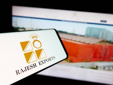 Stuttgart, Almanya - 03-13-2025: Hintli altın şirketi Rajesh Exports Limited 'in logosuna sahip akıllı telefon iş sitesinin önünde ekranda. Telefon ekranının merkez soluna odaklan.