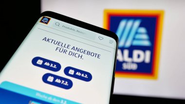 Stuttgart, Almanya - 03-13-2025: Alman perakende şirketi ALDI SUD 'nin logosunun yer aldığı cep telefonu iş sitesinin önünde ekranda. Telefon ekranının sol üst kısmına odaklan.