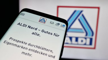 Stuttgart, Almanya - 03-13-2025: Alman ALDI Nord Deutschland Stiftung Co. KG şirketinin logosunun yer aldığı cep telefonu iş sitesinin önünde ekranda. Telefon ekranının sol üst kısmına odaklan.