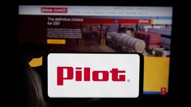 Stuttgart, Almanya - 03-06-2025: ABD 'li Pilot Seyahat Merkezleri LLC (Pilot J) logosuna sahip cep telefonu sahibi kişi iş sayfası önünde ekranda. Telefon ekranına odaklan.