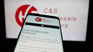 Stuttgart, Almanya - 03-06-2025: İş dünyasının web sitesi önünde üzerinde CS Toptan Bakkal (CSG) logosu bulunan cep telefonu. Telefon ekranının sol üst kısmına odaklan.
