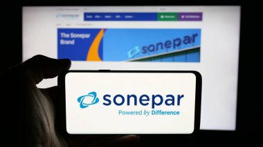 Stuttgart, Almanya - 03-06-2025: Fransız elektronik toptan satış şirketi Sonepar S.A. 'nın logosunu elinde tutan kişi iş sayfası önünde ekranda. Telefon ekranına odaklan.