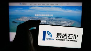 Stuttgart, Almanya - 03-06-2025: Çinli şirket Rongsheng Petrochemical Co. Ltd. (CNRSPC) 'nin logosuyla cep telefonu sahibi kişi iş sayfasının önünde ekranda. Telefon ekranına odaklan.
