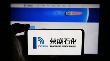 Stuttgart, Almanya - 03-06-2025: Çinli şirket Rongsheng Petrochemical Co. Ltd. (CNRSPC) 'nin logosuyla cep telefonu sahibi kişi iş sayfasının önünde ekranda. Telefon ekranına odaklan.