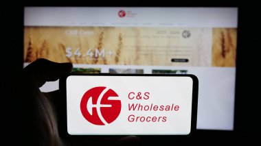 Stuttgart, Almanya - 03-06-2025: İş sayfası önünde ekranda ABD 'li CS Toptancı LLC (CSWG) şirketinin logosunun bulunduğu cep telefonu sahibi kişi. Telefon ekranına odaklan.
