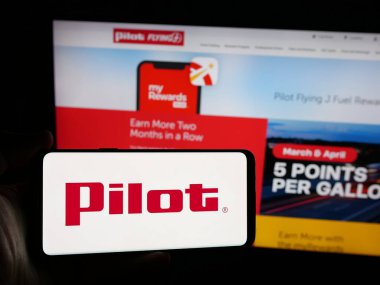 Stuttgart, Almanya - 03-06-2025: Üzerinde ABD 'li Pilot Seyahat Merkezleri LLC (Pilot J) logosu bulunan kişi iş dünyasının web sitesinin önünde ekranda görülüyor. Telefon ekranına odaklan.