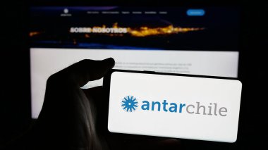 Stuttgart, Almanya - 03-06-2025: Şilili şirket AntarŞili 'nin logosunun bulunduğu cep telefonu sahibi kişi iş sayfasının önünde ekranda. Telefon ekranına odaklan.