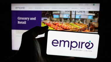 Stuttgart, Almanya - 03-06-2025: Kanada şirketi Empire Limited 'in logosunun bulunduğu cep telefonu sahibi kişi iş sayfasının önünde ekranda. Telefon ekranına odaklan.