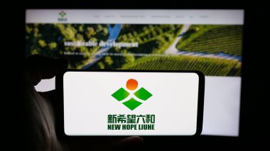 Stuttgart, Almanya - 03-06-2025: Çinli gıda şirketi Yeni Umut Liuhe Co. Ltd. 'nin logosunu taşıyan kişi iş sayfasının önünde ekranda. Telefon ekranına odaklan.