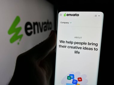 Stuttgart, Almanya - 03-07-2025: Avustralyalı içerik platformu şirketi Envato 'nun web sayfası olan cep telefonu logosu önünde ekranda. Telefon ekranının merkezine odaklan.