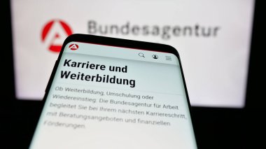 Stuttgart, Almanya - 03-07-2025: Alman federal ajansı Bundesagentur fuer Arbeit 'in logosuna sahip cep telefonu web sitesinin önünde ekranda. Telefon ekranının sol üst kısmına odaklan.