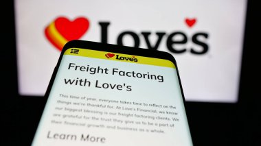 Stuttgart, Almanya - 03-07-2025: ABD 'li Love' s Travel Stops Country Stores Inc. şirketinin logosunu içeren cep telefonu web sitesinin önünde ekranda. Telefon ekranının sol üst kısmına odaklan.