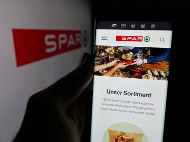 Stuttgart, Almanya - 03-07-2025: Üzerinde İsviçreli perakende şirketi SPAR Holding AG 'nin logosu bulunan web sayfası logonun önünde ekranda. Telefon ekranının merkezine odaklan.