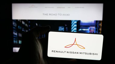 Stuttgart, Almanya - 03-07-2025: Otomotiv kuruluşu Renault-Nissan-Mitsubishi Alliance 'ın logosunu taşıyan cep telefonu, iş dünyasının web sayfası önünde ekranda. Telefon ekranına odaklan.